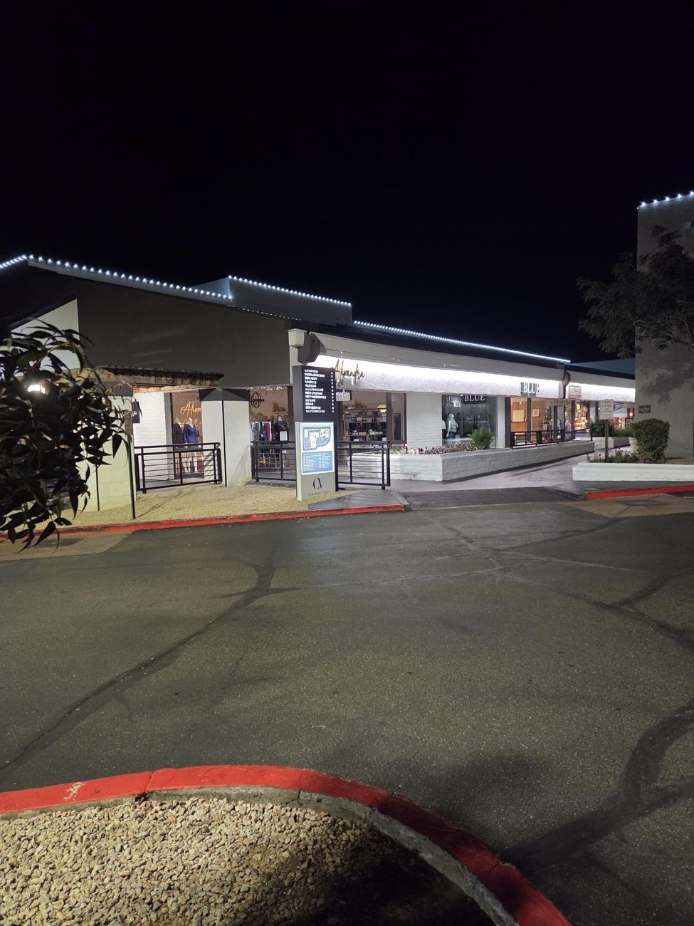 Warm C9 LED roofline lighting on a modern Arizona shopping village at night.